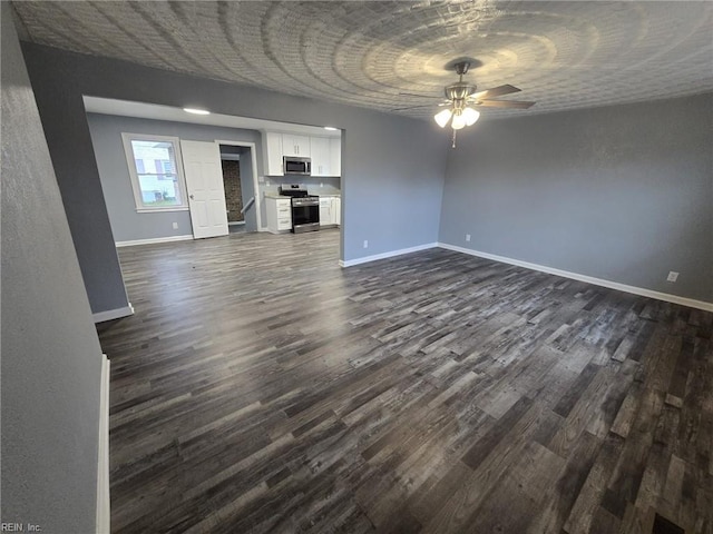 unfurnished living room featuring dark wood-type flooring and ceiling fan