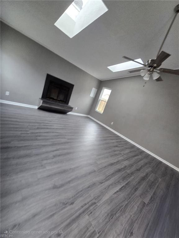 unfurnished living room featuring ceiling fan, vaulted ceiling with skylight, and dark hardwood / wood-style flooring