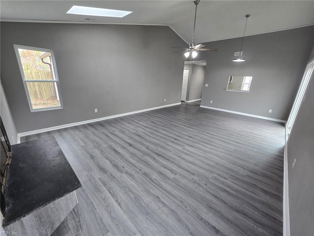 unfurnished living room featuring dark hardwood / wood-style floors, ceiling fan, and vaulted ceiling with skylight