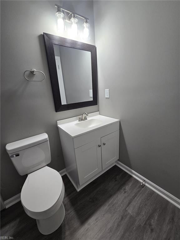 bathroom featuring wood-type flooring, toilet, and vanity