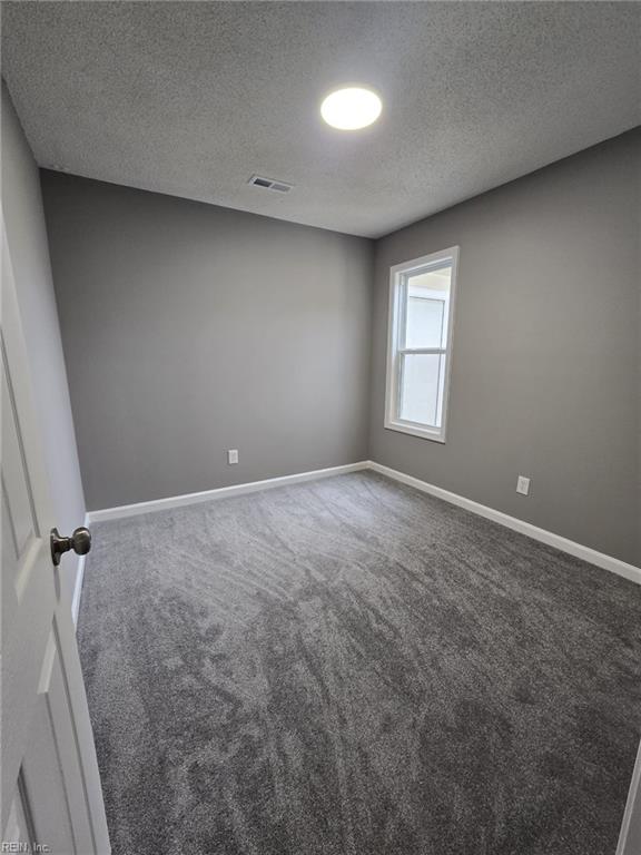 unfurnished room featuring carpet floors and a textured ceiling