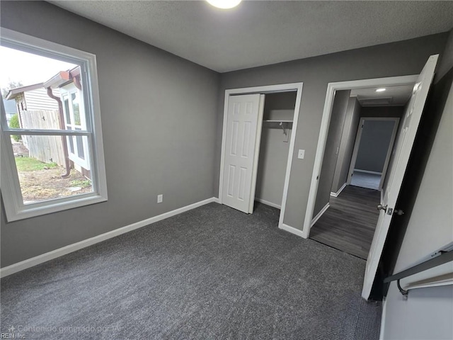 unfurnished bedroom featuring dark carpet and a closet