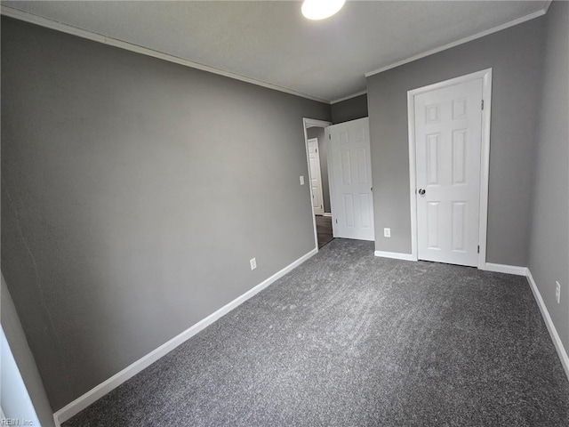 unfurnished bedroom with crown molding and dark colored carpet