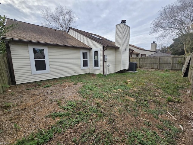 back of property featuring cooling unit and a lawn