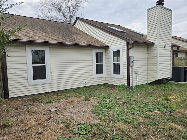 back of house featuring cooling unit and a lawn