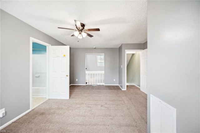 unfurnished room with carpet flooring, a textured ceiling, and ceiling fan