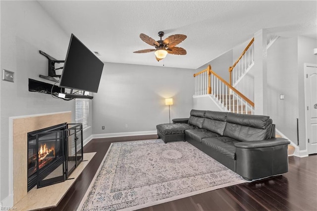 living room with dark hardwood / wood-style flooring, a textured ceiling, and ceiling fan