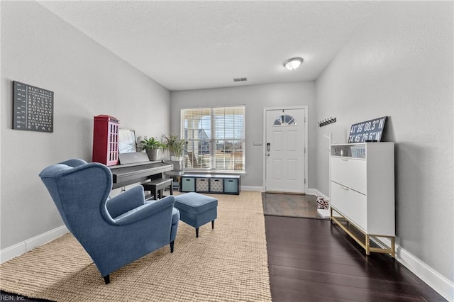 sitting room with hardwood / wood-style floors and a textured ceiling