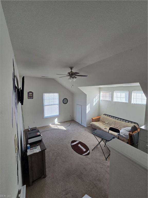 living room with lofted ceiling, a textured ceiling, light colored carpet, and ceiling fan