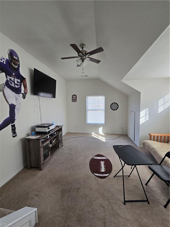 unfurnished living room featuring vaulted ceiling, light colored carpet, and ceiling fan