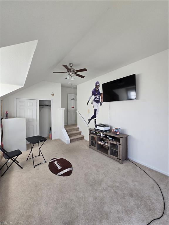 sitting room featuring ceiling fan, light colored carpet, and lofted ceiling