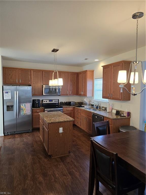 kitchen featuring sink, a center island, hanging light fixtures, dark hardwood / wood-style flooring, and stainless steel appliances