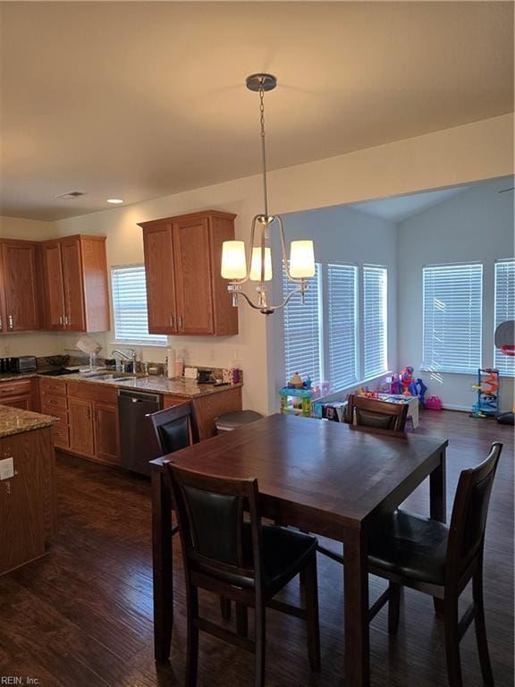 dining room featuring dark hardwood / wood-style flooring, sink, vaulted ceiling, and a chandelier