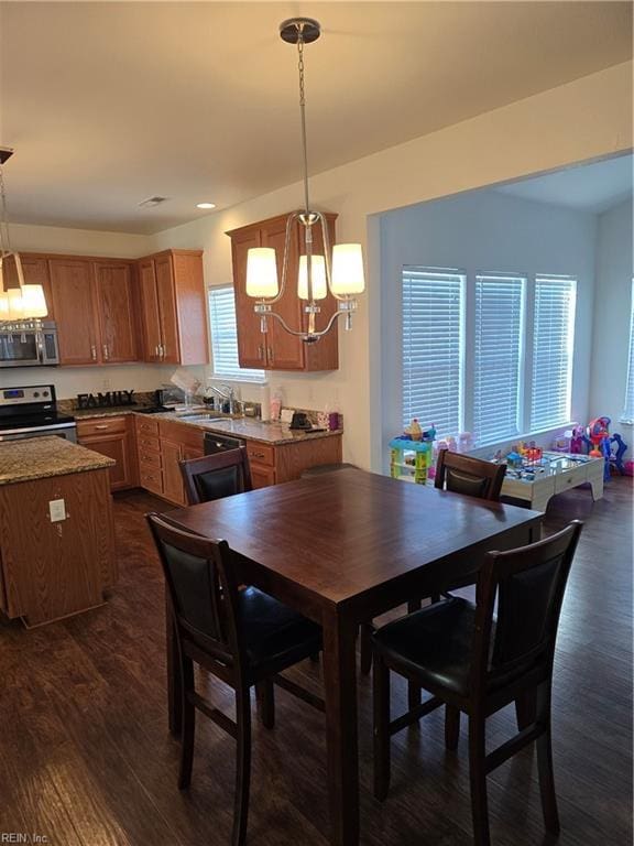 dining room featuring dark hardwood / wood-style floors, sink, and a notable chandelier