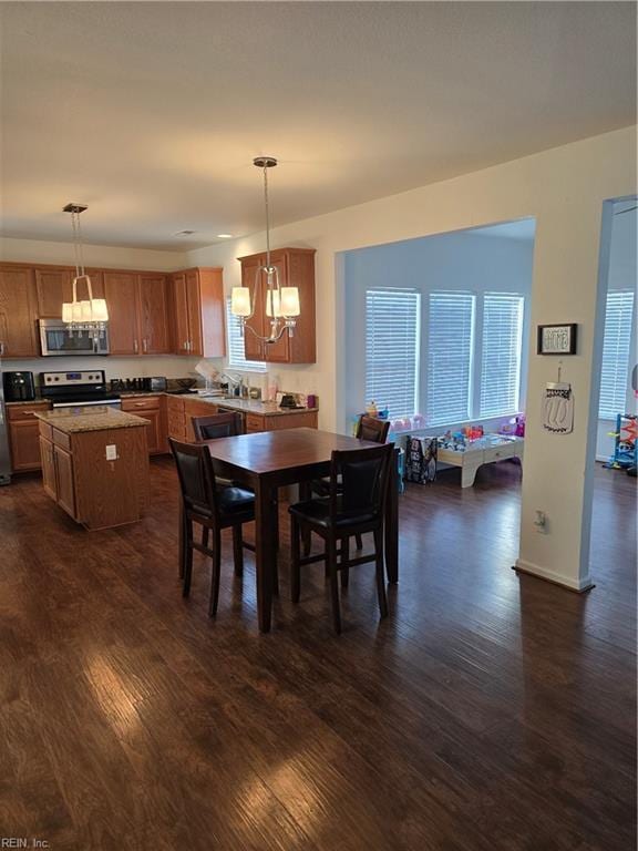 dining room featuring a notable chandelier, plenty of natural light, and dark hardwood / wood-style floors