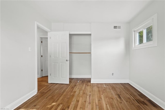 unfurnished bedroom featuring hardwood / wood-style floors and a closet