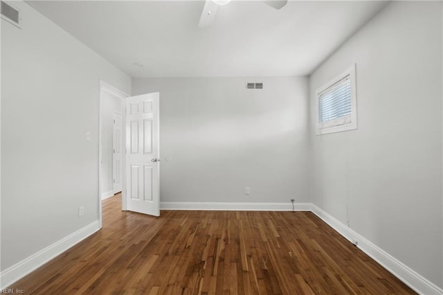 spare room featuring dark hardwood / wood-style flooring and ceiling fan