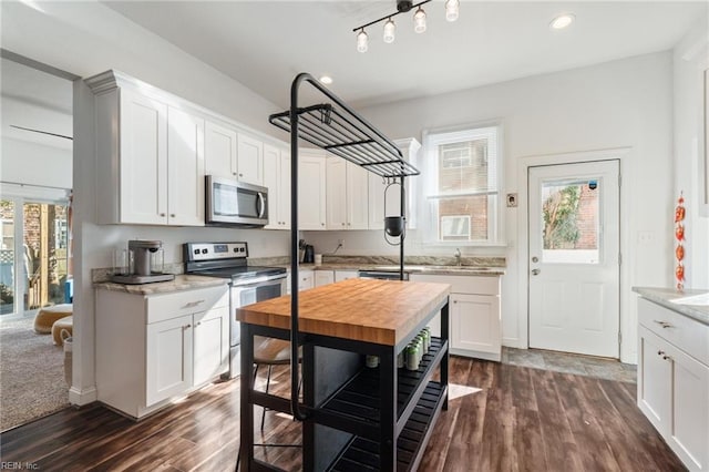 kitchen featuring butcher block countertops, dark hardwood / wood-style floors, white cabinets, and appliances with stainless steel finishes