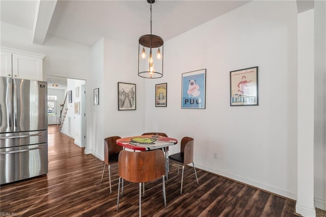 dining space with beam ceiling and dark hardwood / wood-style floors