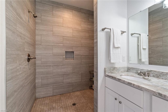 bathroom with vanity and a tile shower