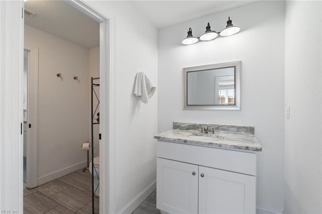 bathroom featuring vanity, hardwood / wood-style floors, and toilet