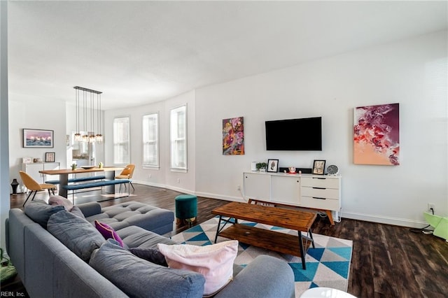 living room with dark hardwood / wood-style flooring and a notable chandelier