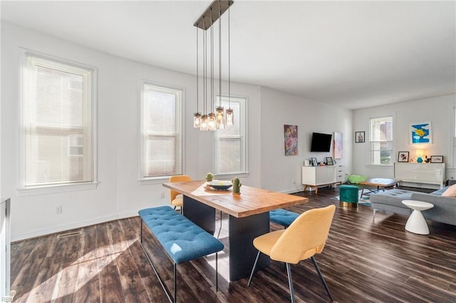 dining area featuring dark wood-type flooring and a chandelier