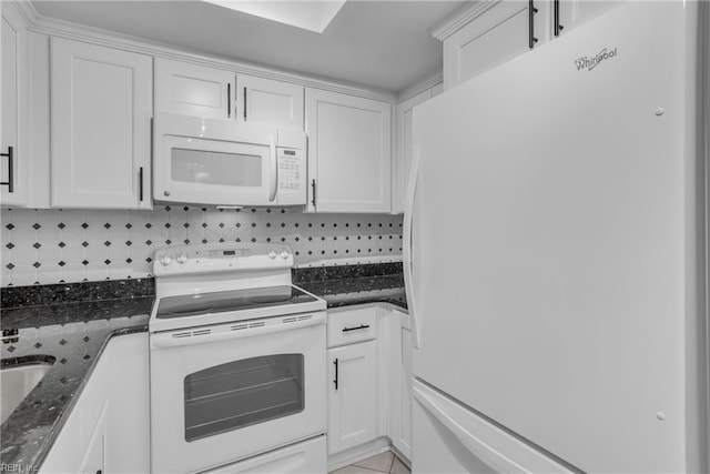 kitchen featuring light tile patterned flooring, white cabinetry, tasteful backsplash, white appliances, and dark stone counters