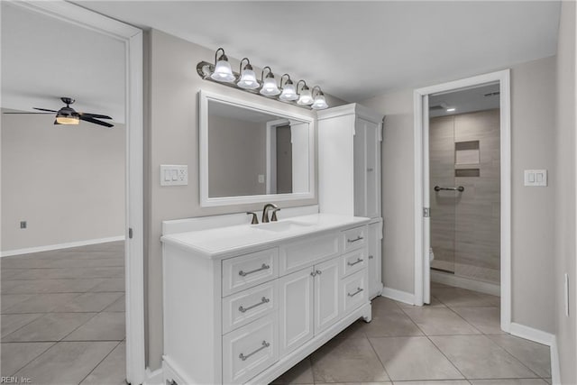 bathroom with tile patterned floors, toilet, an enclosed shower, vanity, and ceiling fan