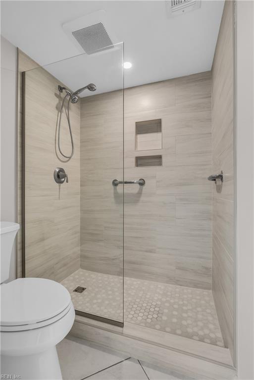 bathroom with toilet and tiled shower