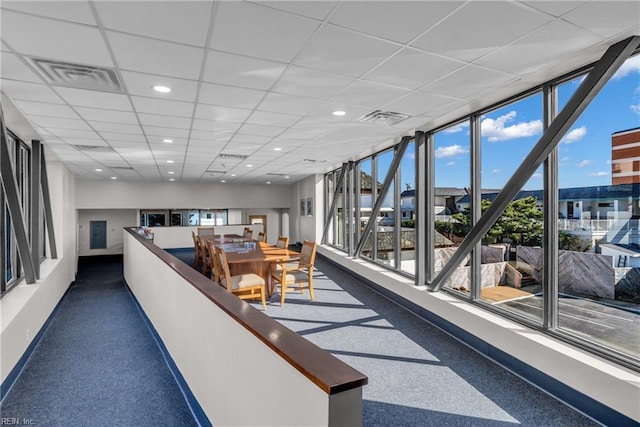 interior space with a paneled ceiling and expansive windows