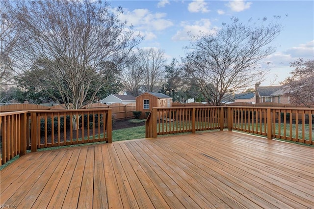 wooden terrace with a storage unit and a lawn