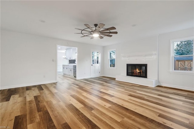 unfurnished living room featuring light hardwood / wood-style floors and ceiling fan