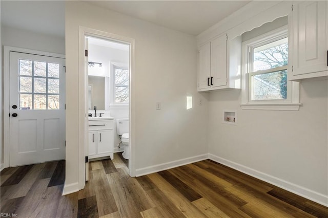 washroom with sink, dark wood-type flooring, a wealth of natural light, and hookup for a washing machine