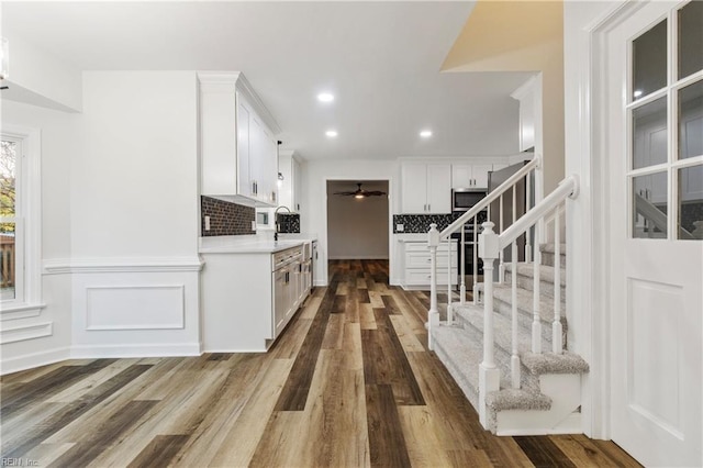 kitchen with decorative backsplash, wood-type flooring, and white cabinets