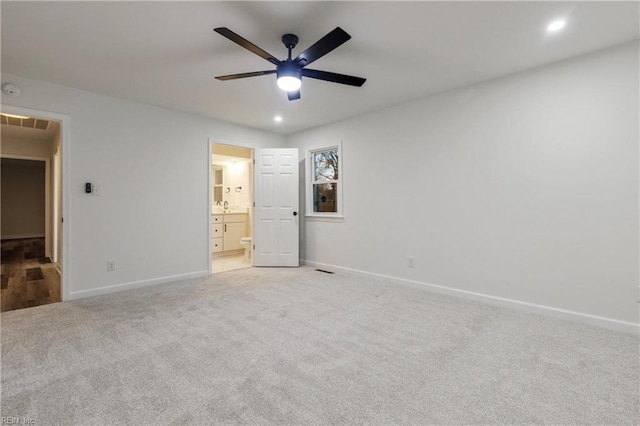 unfurnished bedroom featuring light carpet, sink, ensuite bath, and ceiling fan