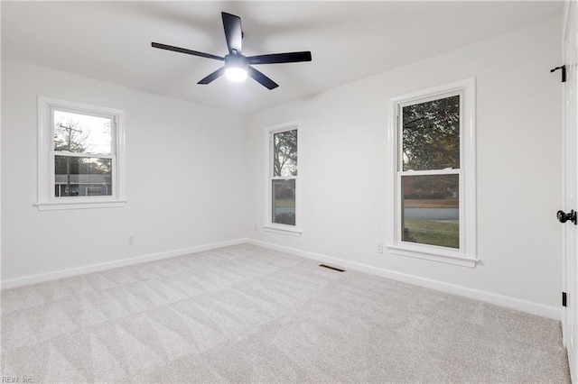 carpeted spare room featuring ceiling fan