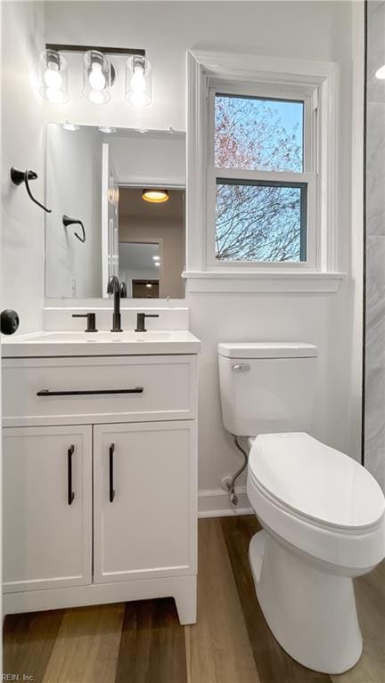 bathroom featuring vanity, toilet, and hardwood / wood-style floors