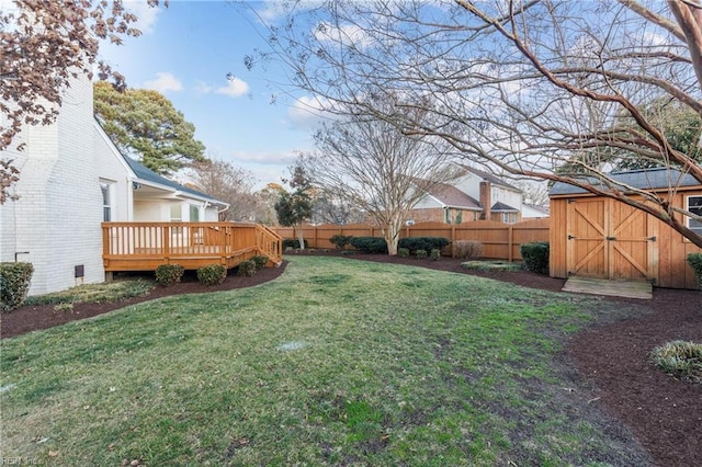 view of yard featuring a wooden deck and a storage shed