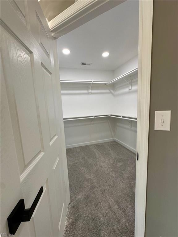 spacious closet featuring dark carpet