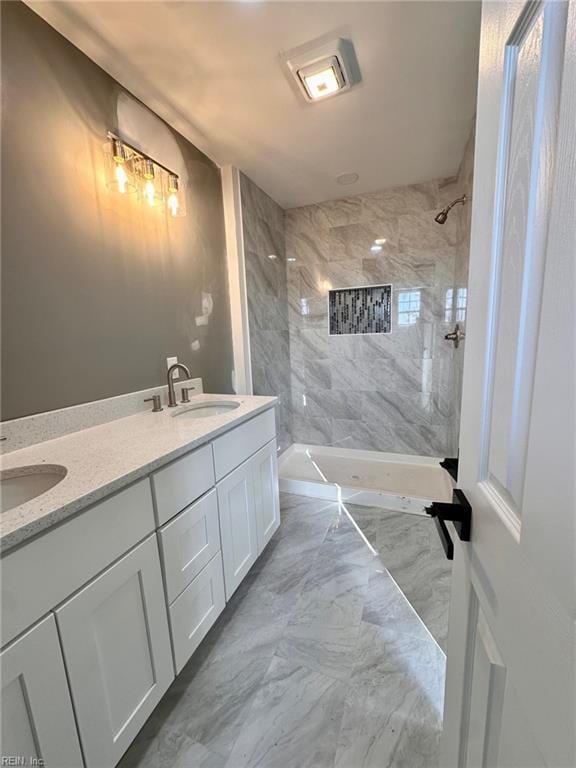 bathroom featuring vanity and tiled shower