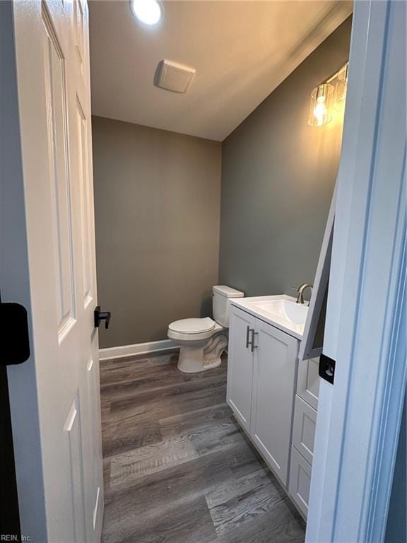 bathroom featuring wood-type flooring, vanity, and toilet