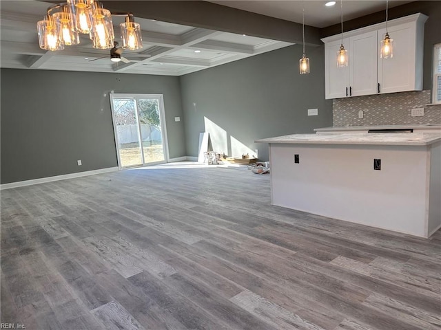 unfurnished living room featuring coffered ceiling, beam ceiling, light hardwood / wood-style floors, and ceiling fan