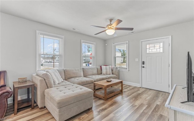 living room with ceiling fan and light hardwood / wood-style flooring