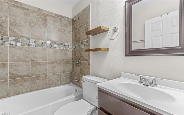 full bathroom with vanity, tiled shower / bath, and toilet