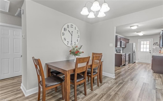 dining room with a chandelier and light wood-type flooring