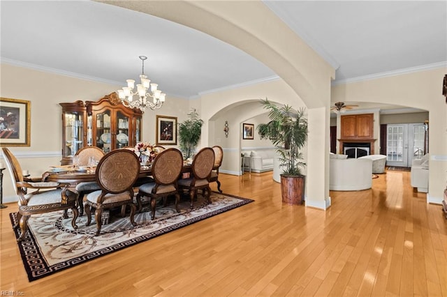 dining area featuring crown molding, ceiling fan with notable chandelier, and light hardwood / wood-style flooring