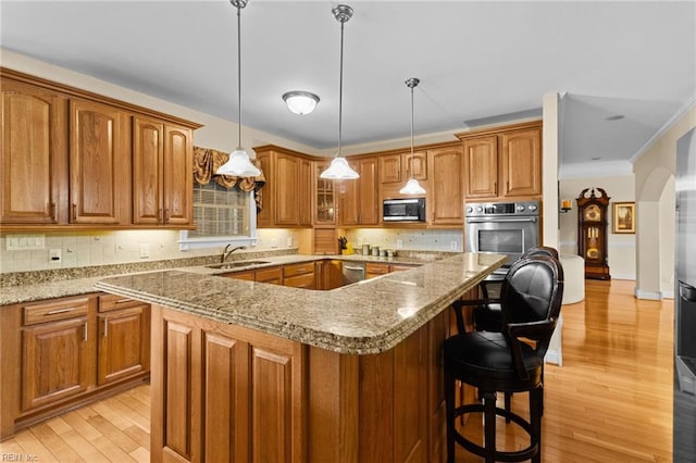 kitchen featuring light hardwood / wood-style floors, hanging light fixtures, stainless steel appliances, and a center island