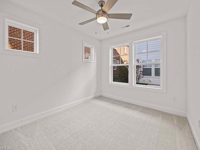 empty room featuring ceiling fan and carpet