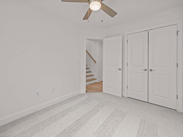 unfurnished bedroom with light colored carpet, ceiling fan, and a closet